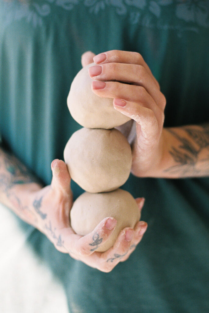 Hands holding clay balls